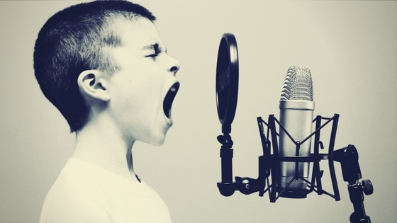 Boy screaming into microphone